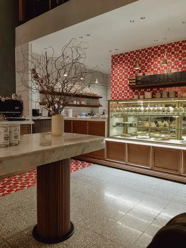 Warm and welcoming café interior with marble counter tables and elegant glassware