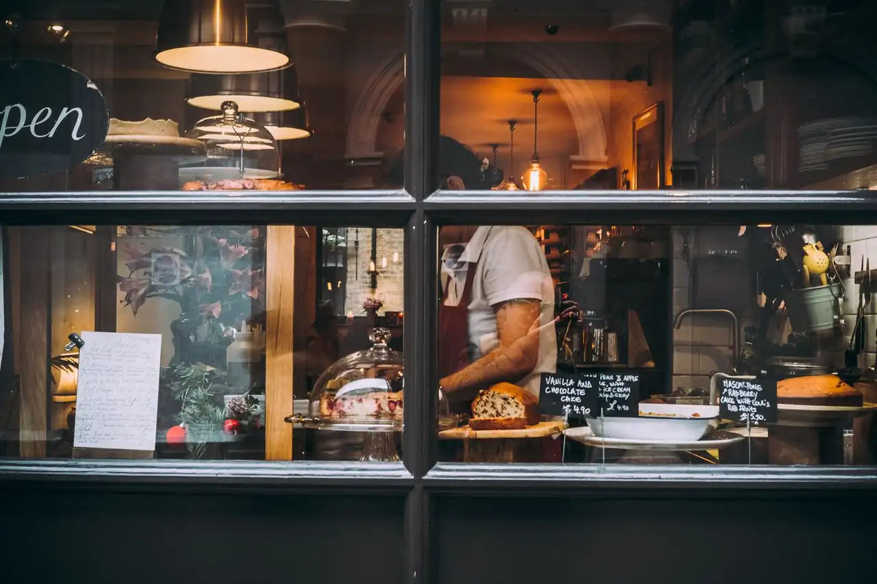 Atmospheric London patisserie kitchen with pastry chef handcrafting delicate creations