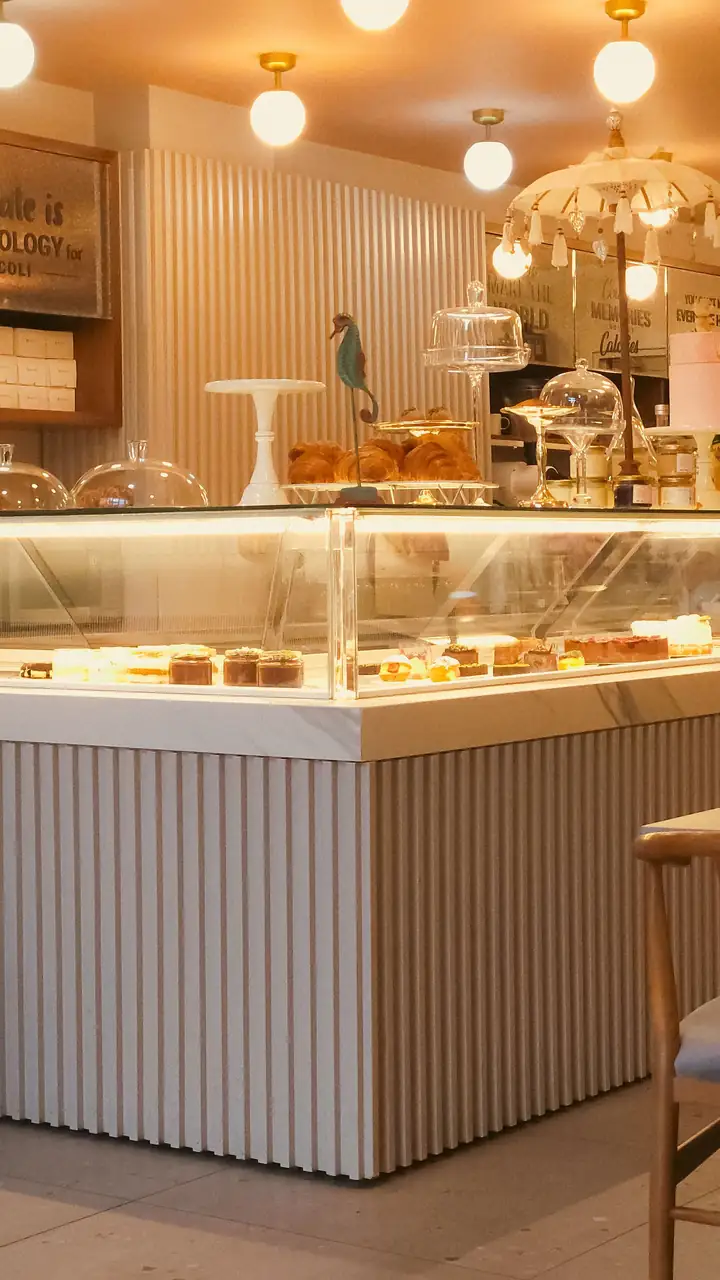 Warm interior illumination framing clean patisserie seating and counter tables