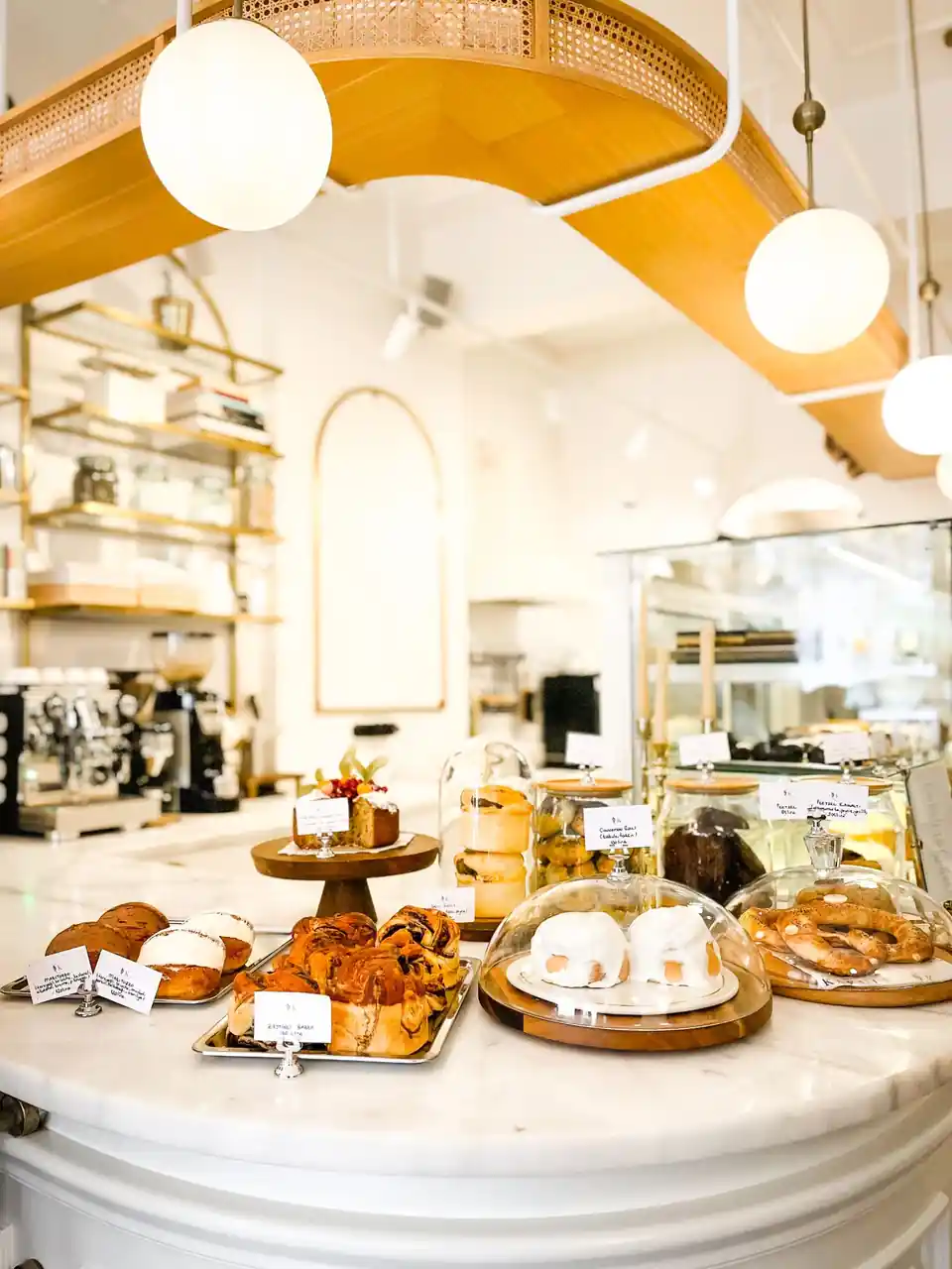 Quiet morning cafe vitrine displaying handcrafted gateaux and fresh viennoiseries