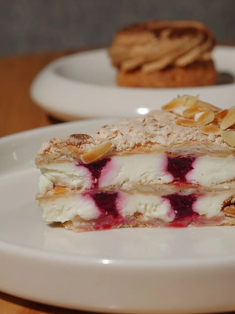 Layered berry cream cake demonstrating precise pastry craftsmanship and fresh garnishes