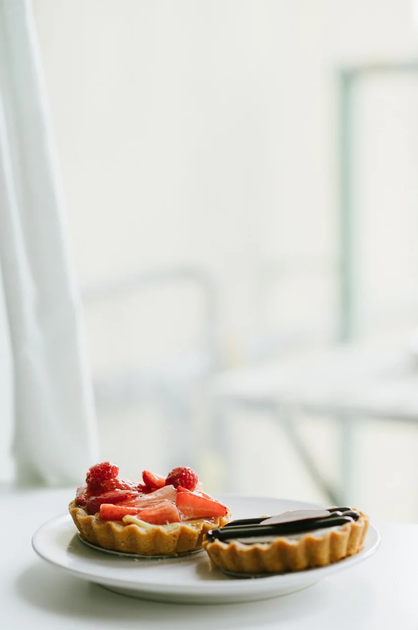 Artisanal tartlets with fresh strawberries and chocolate ganache served on fine tableware
