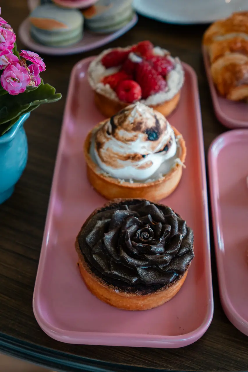 Artisan fruit and chocolate tartlets on an ivory patisserie platter