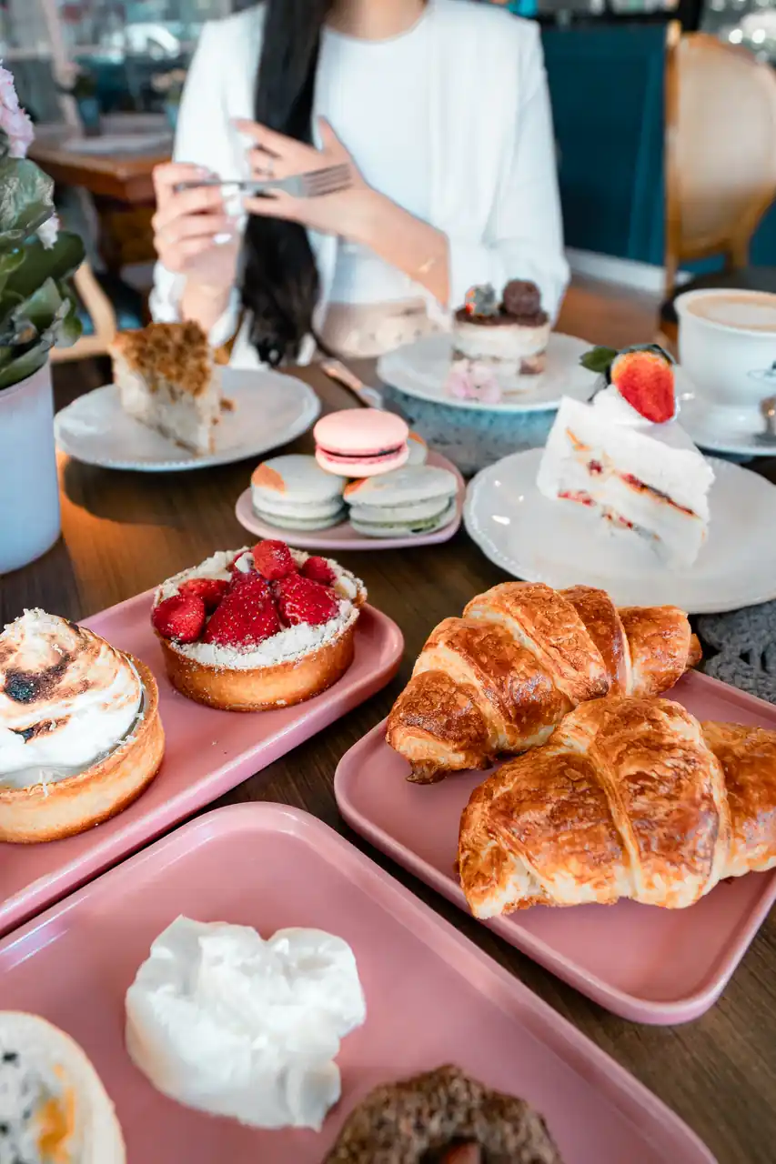 Artfully arranged table with delicate breakfast pastries, fresh fruit, and speciality beverages